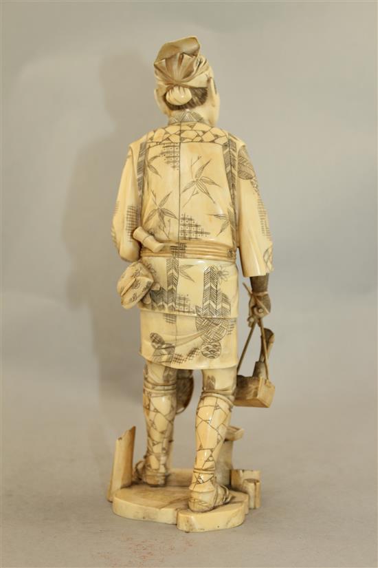 A Japanese sectional walrus ivory figure of a fan seller, early 20th century, 27.5cm